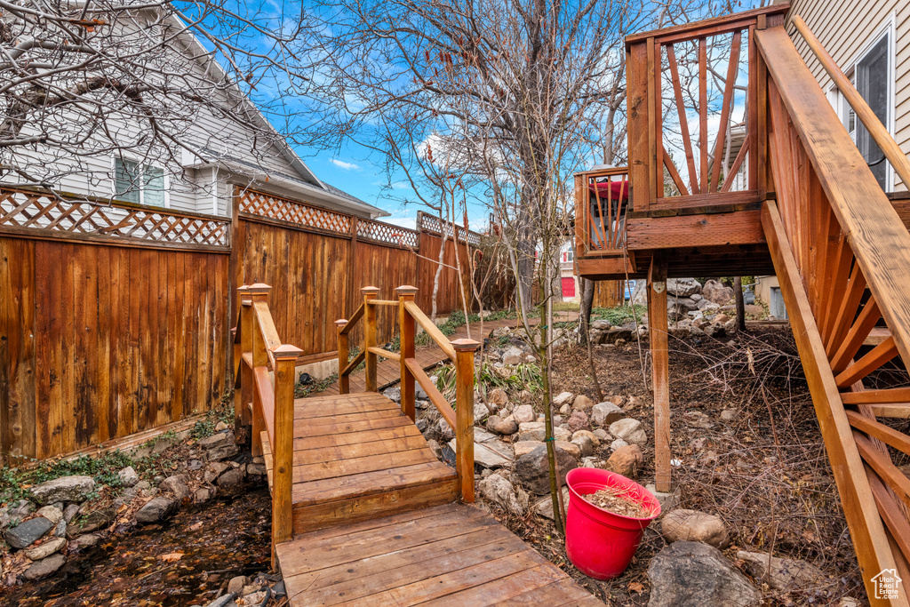 Wooden terrace with a fenced backyard
