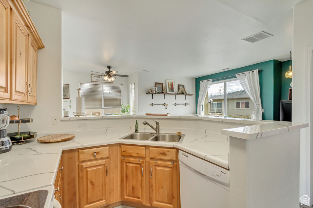 Kitchen with visible vents, a ceiling fan, white dishwasher, light countertops, and a sink