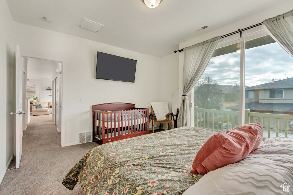 Bedroom featuring baseboards, carpet flooring, visible vents, and access to exterior