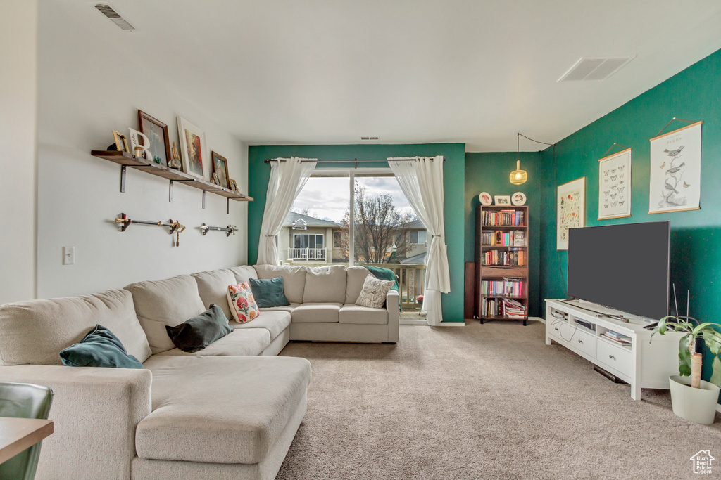 Living area featuring visible vents and carpet flooring