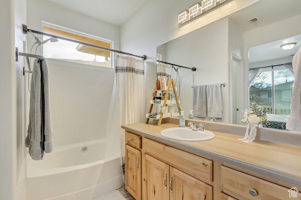 Full bath with shower / bath combination with curtain, plenty of natural light, and vanity