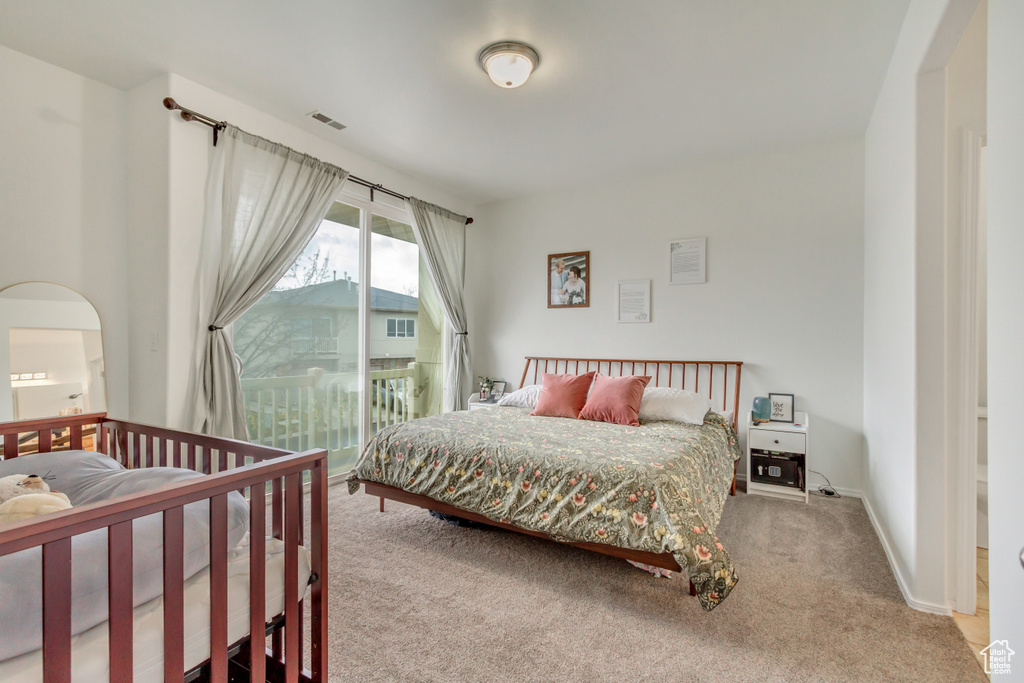 Bedroom with carpet, arched walkways, visible vents, access to outside, and baseboards