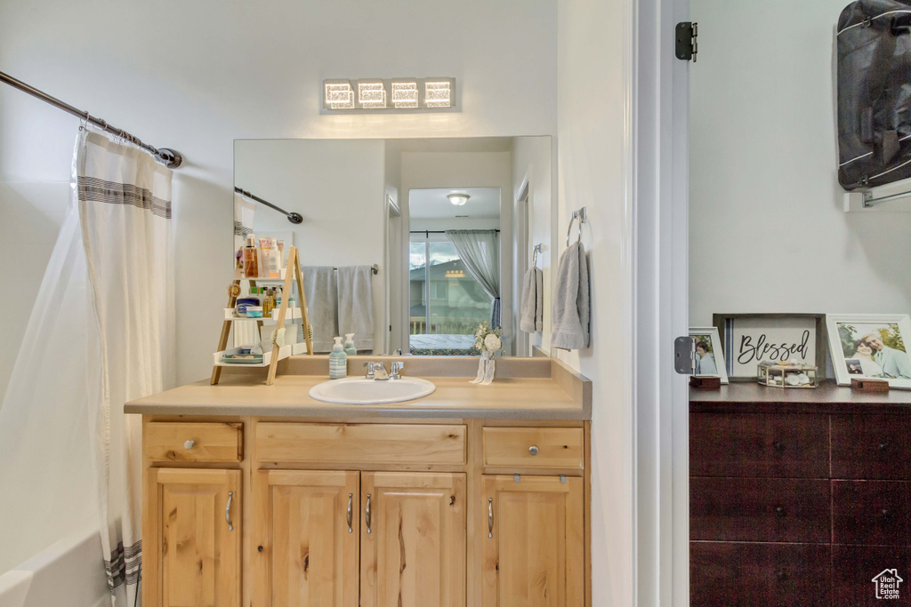 Bathroom featuring a shower with shower curtain and vanity