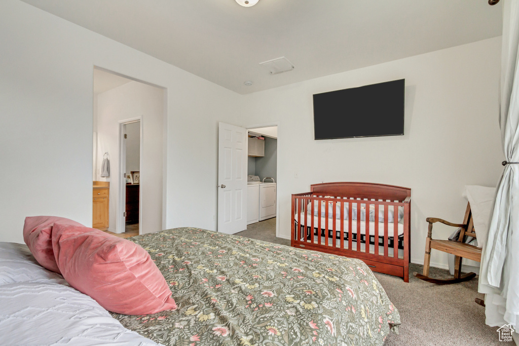 Carpeted bedroom with baseboards and washer and dryer