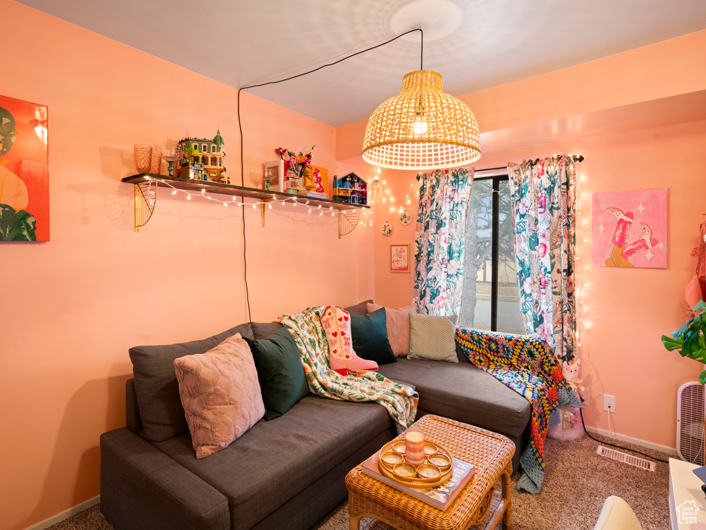 Living area with carpet flooring, visible vents, and baseboards