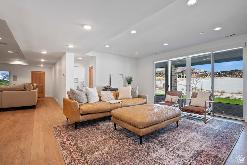 Living room with baseboards, light wood finished floors, visible vents, and recessed lighting