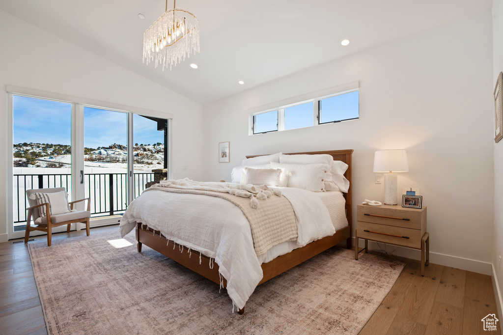 Bedroom featuring a chandelier, recessed lighting, vaulted ceiling, access to outside, and hardwood / wood-style floors