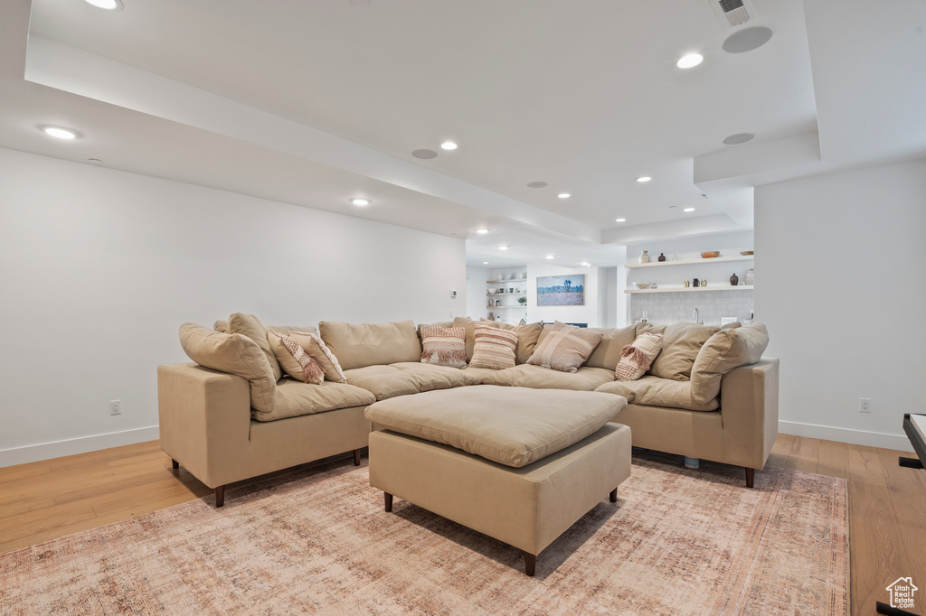 Living area with baseboards, light wood finished floors, and recessed lighting