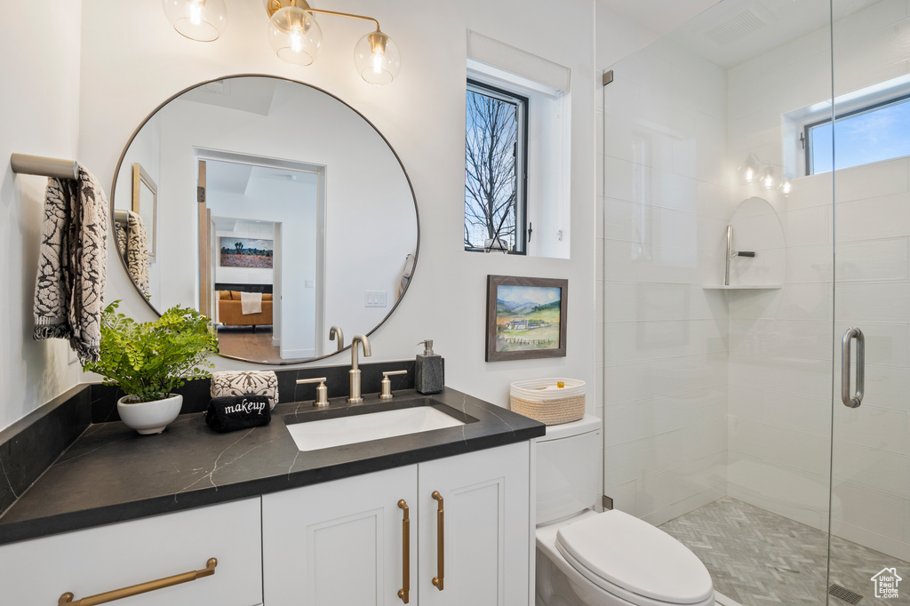 Bathroom with a stall shower, vanity, and toilet