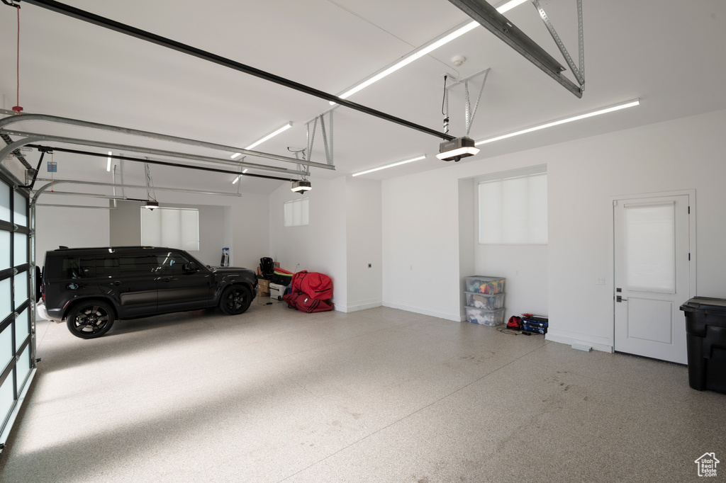 Garage with baseboards and a garage door opener