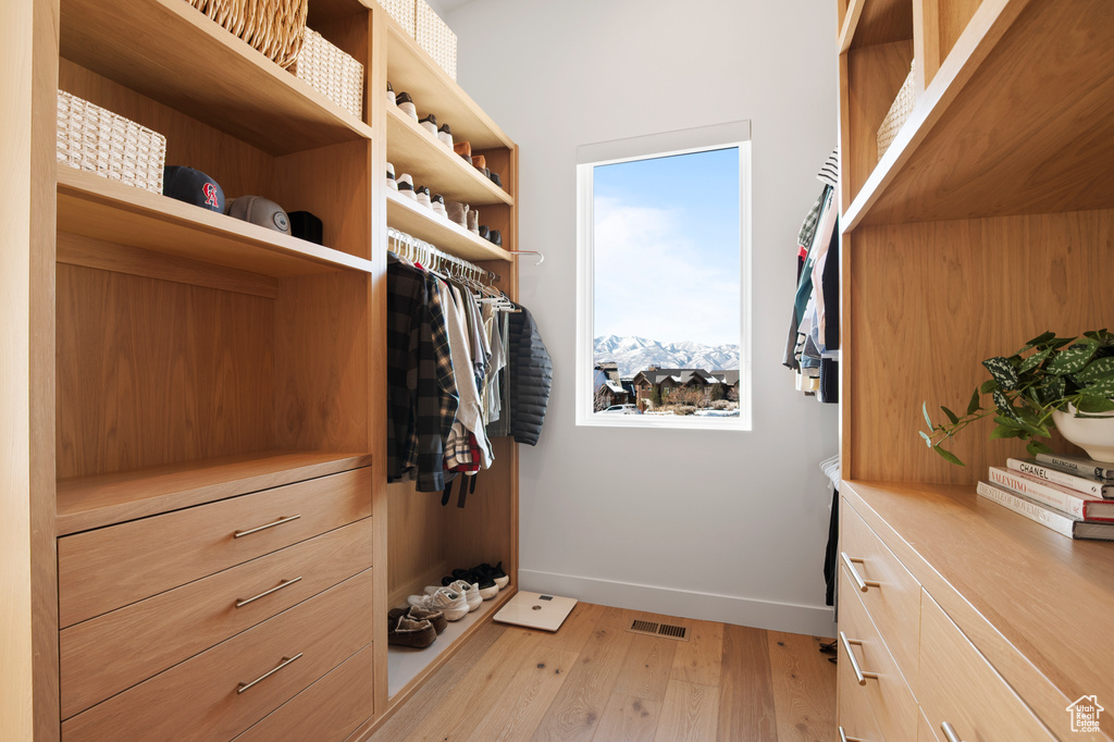 Walk in closet featuring light wood-type flooring and visible vents