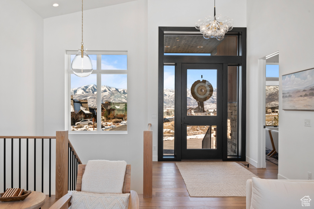 Entryway featuring recessed lighting, a notable chandelier, a towering ceiling, and wood finished floors