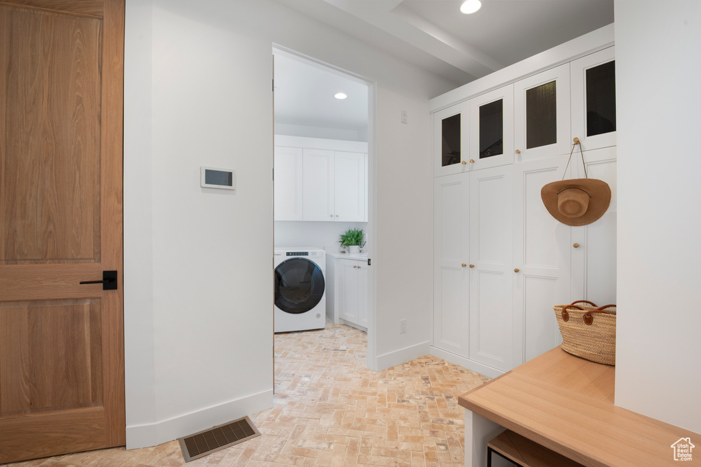 Washroom with recessed lighting, visible vents, baseboards, cabinet space, and washer / dryer