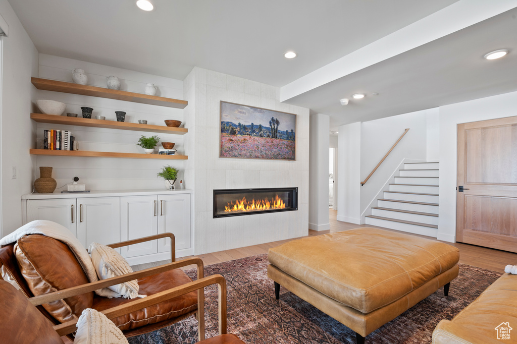 Interior space featuring light wood-type flooring, stairs, a fireplace, and recessed lighting