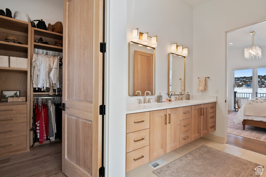 Full bath featuring a walk in closet, visible vents, a sink, and double vanity