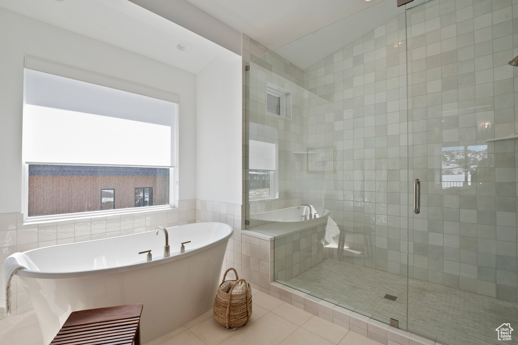 Bathroom with a stall shower, tile patterned flooring, a freestanding tub, and lofted ceiling