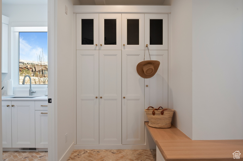 Mudroom with brick floor, a sink, and visible vents