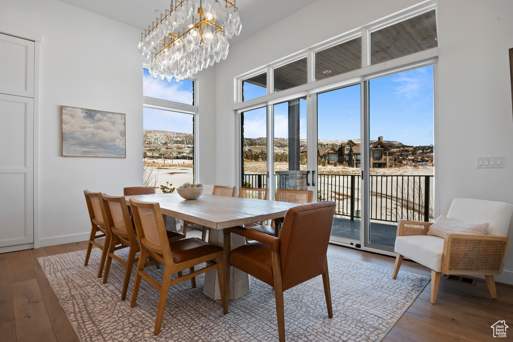 Dining room featuring a notable chandelier, baseboards, and hardwood / wood-style flooring