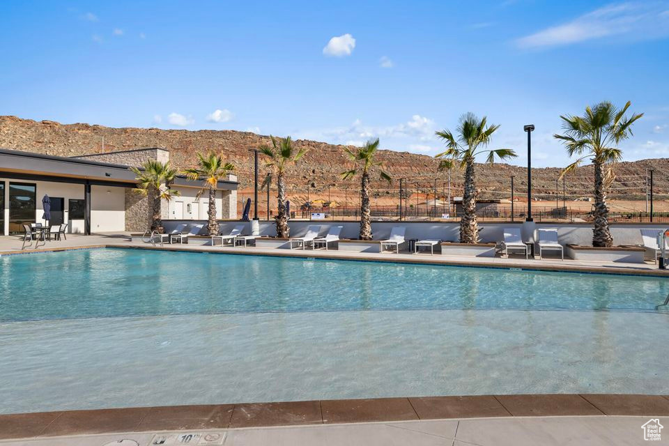 Pool with a patio area and fence