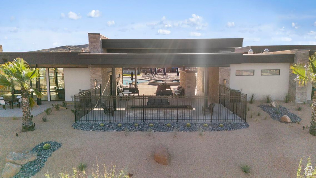 Rear view of property featuring a patio area, fence, and stucco siding