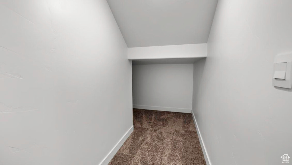 Corridor featuring carpet flooring and baseboards