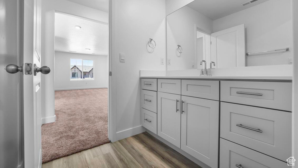 Bathroom with baseboards, wood finished floors, and vanity
