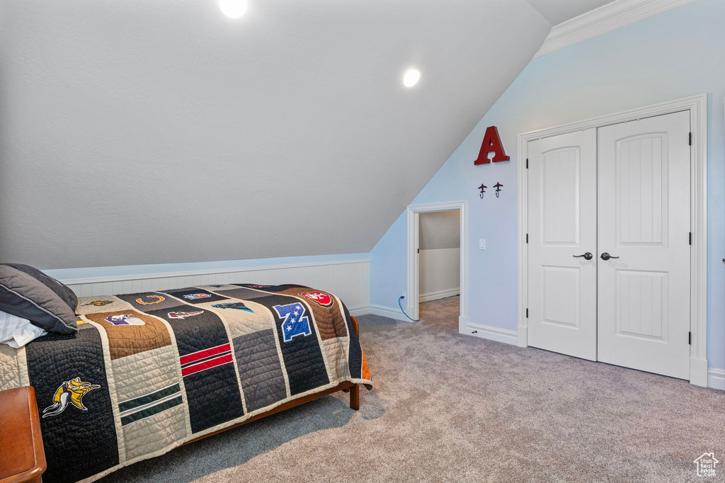 Bedroom with carpet, a closet, lofted ceiling, and baseboards
