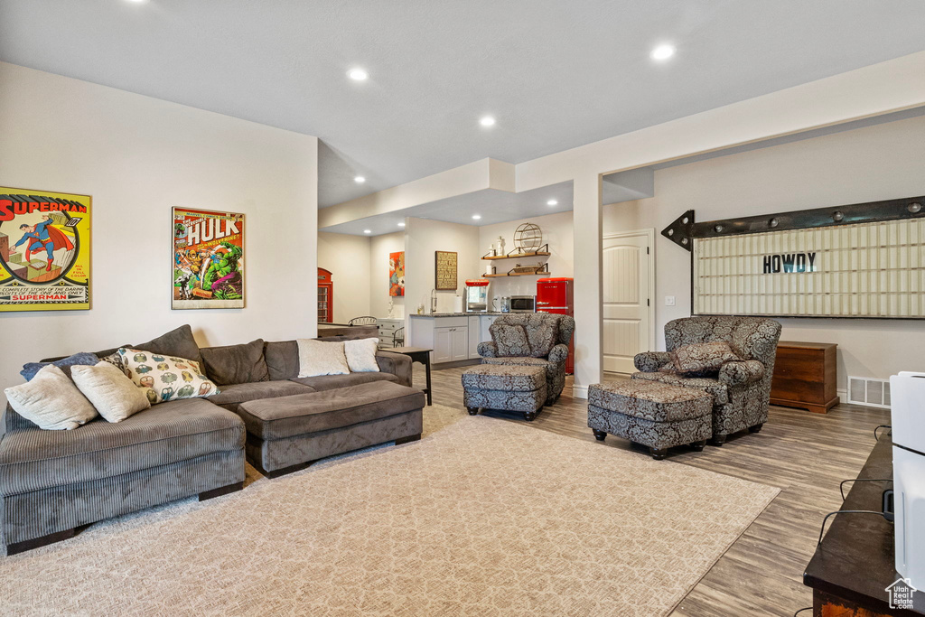 Living area with baseboards, wood finished floors, visible vents, and recessed lighting