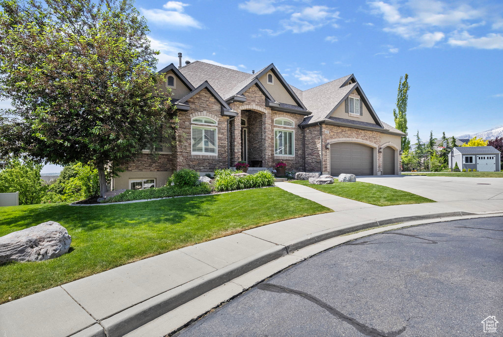 Craftsman inspired home featuring a garage, a shingled roof, concrete driveway, stucco siding, and a front lawn