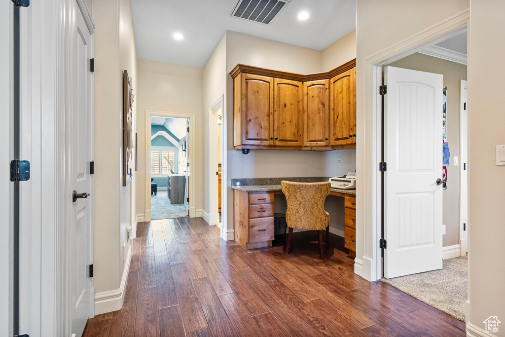 Office space featuring recessed lighting, visible vents, baseboards, built in study area, and dark wood-style floors
