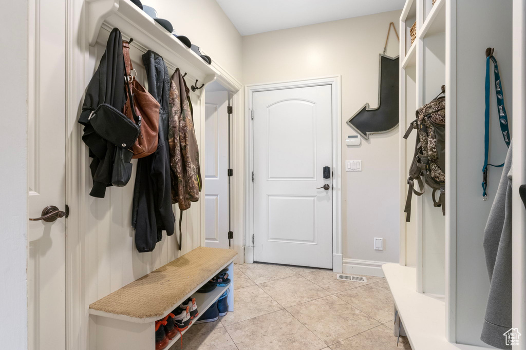 Mudroom with light tile patterned floors, visible vents, and baseboards