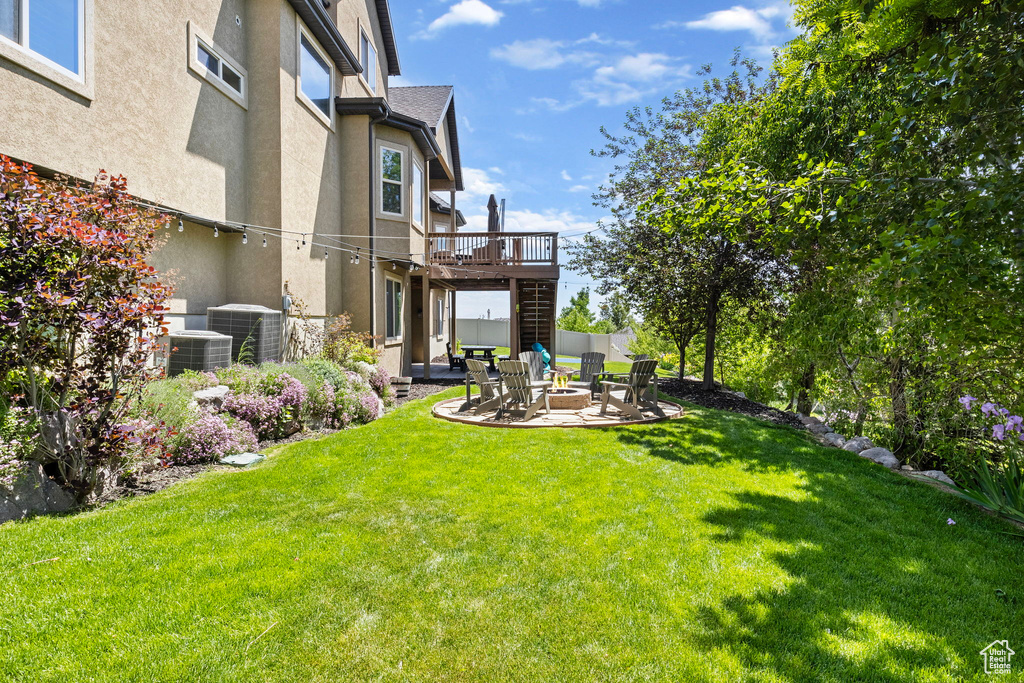 View of yard with central air condition unit, stairway, a patio area, a fire pit, and a wooden deck