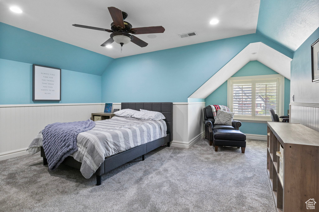 Bedroom with vaulted ceiling, carpet floors, ceiling fan, and visible vents