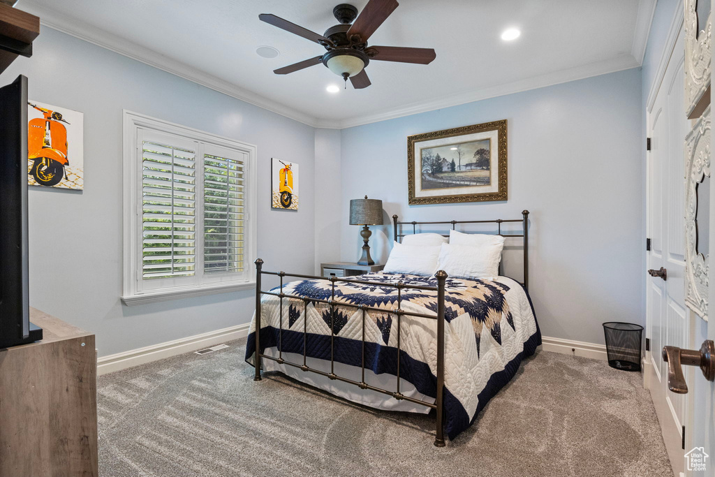 Carpeted bedroom featuring recessed lighting, a ceiling fan, visible vents, baseboards, and ornamental molding