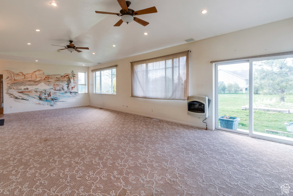 Unfurnished living room with a ceiling fan, heating unit, and carpet