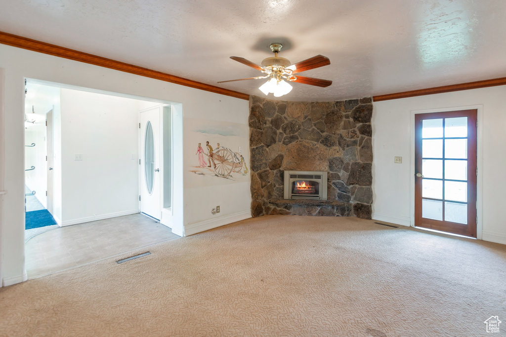 Unfurnished living room featuring carpet flooring, a ceiling fan, heating unit, and ornamental molding