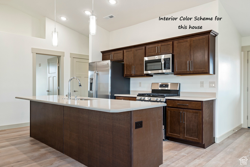 Kitchen with light countertops, stainless steel appliances, visible vents, and a sink
