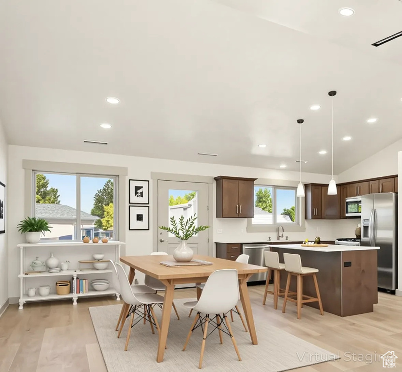 Dining area with light wood-type flooring, recessed lighting, and lofted ceiling