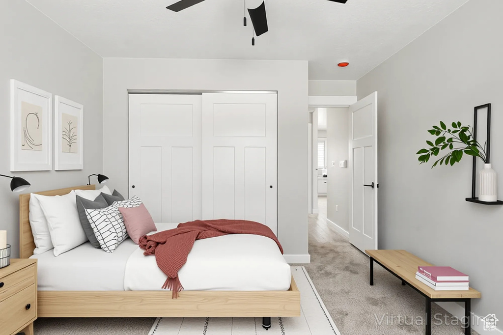 Carpeted bedroom with baseboards, a ceiling fan, and a closet