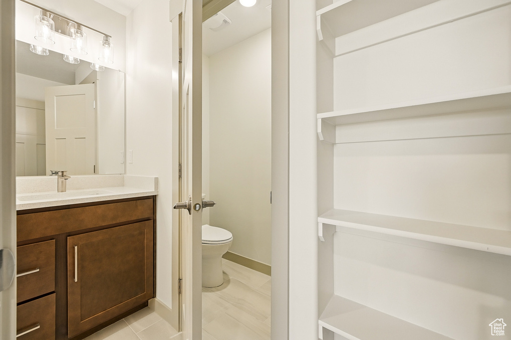Bathroom featuring toilet, vanity, baseboards, and marble finish floors