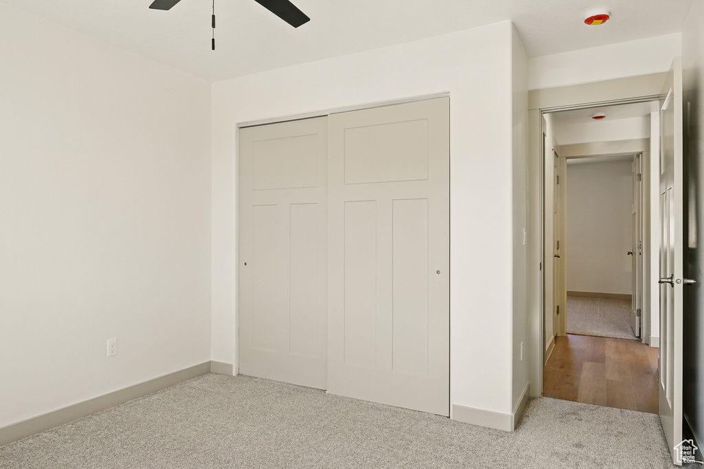 Unfurnished bedroom with carpet floors, baseboards, a closet, and ceiling fan