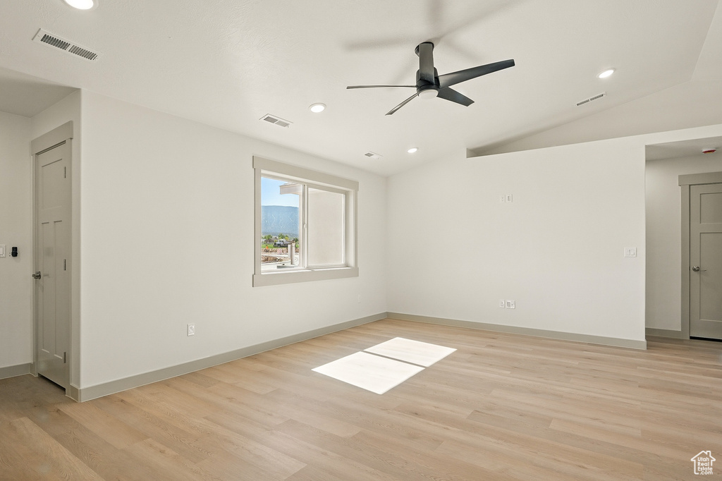 Empty room with light wood-style flooring, recessed lighting, ceiling fan, vaulted ceiling, and baseboards