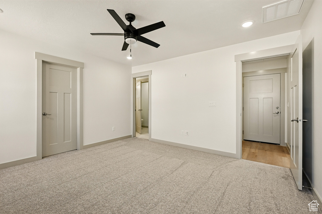 Unfurnished bedroom with light colored carpet, recessed lighting, baseboards, ensuite bath, and a ceiling fan
