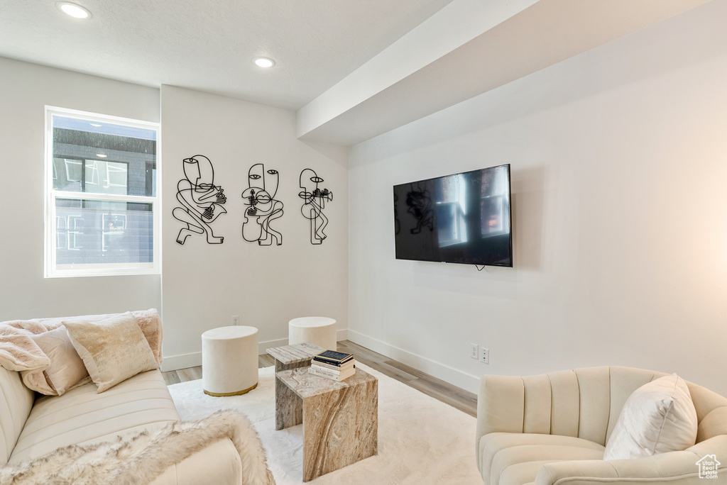 Living room with baseboards, wood finished floors, and recessed lighting