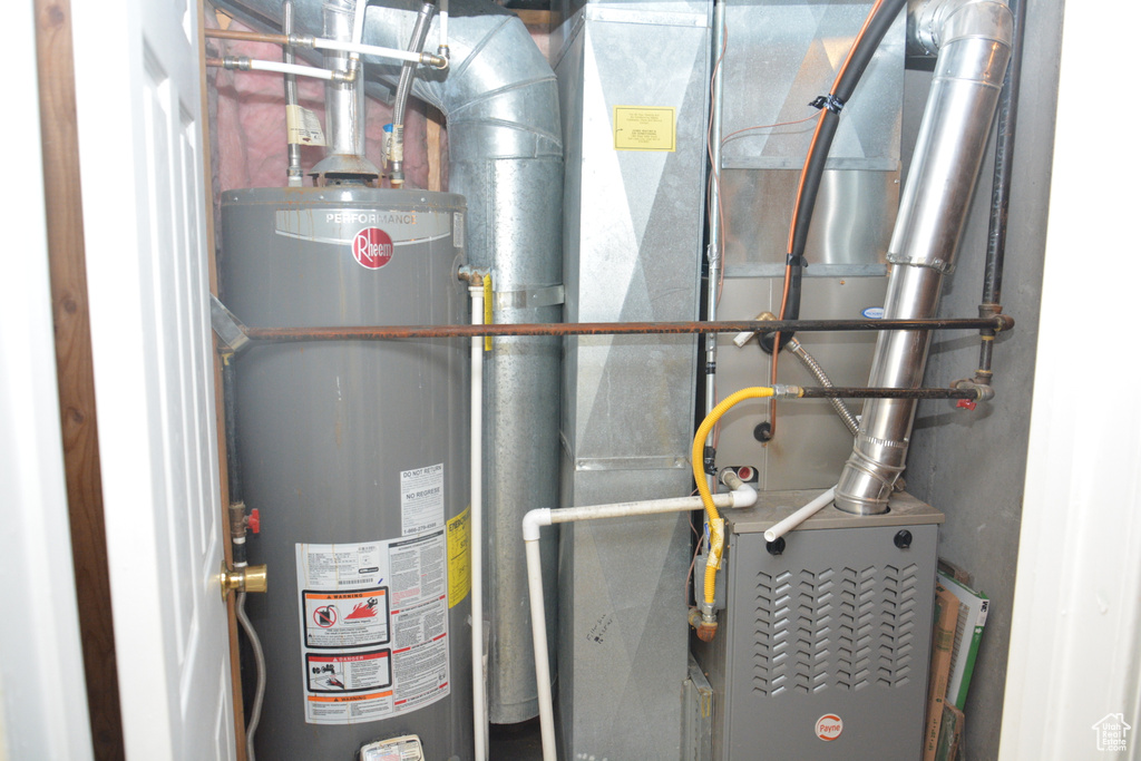 Utility room featuring heating unit and water heater