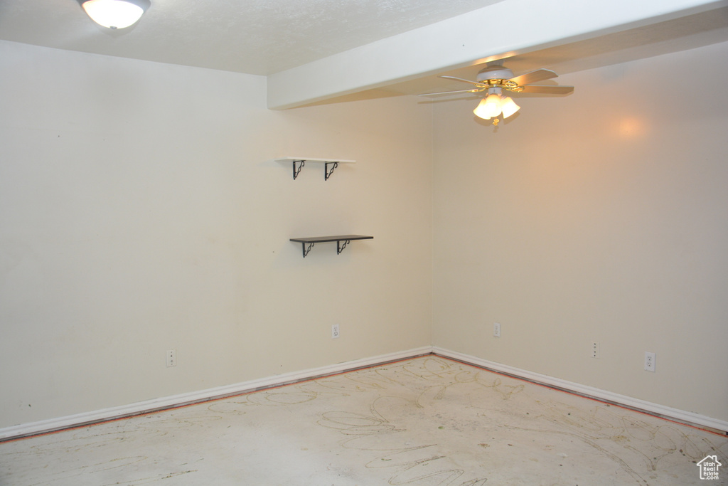 Spare room with baseboards, unfinished concrete flooring, and ceiling fan