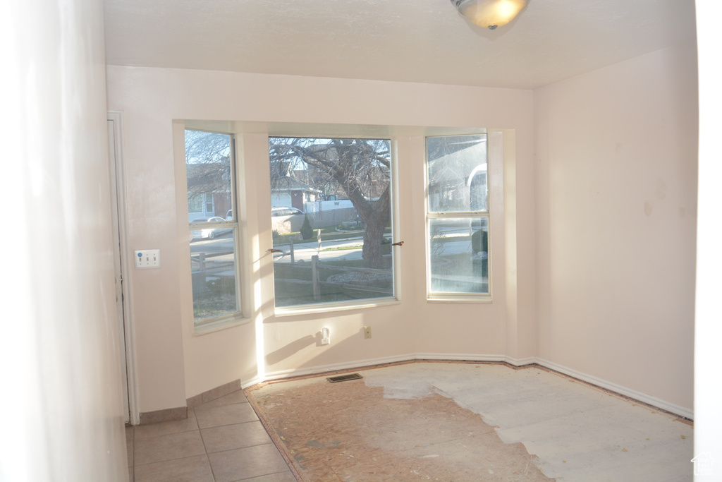 Tiled spare room with baseboards and visible vents