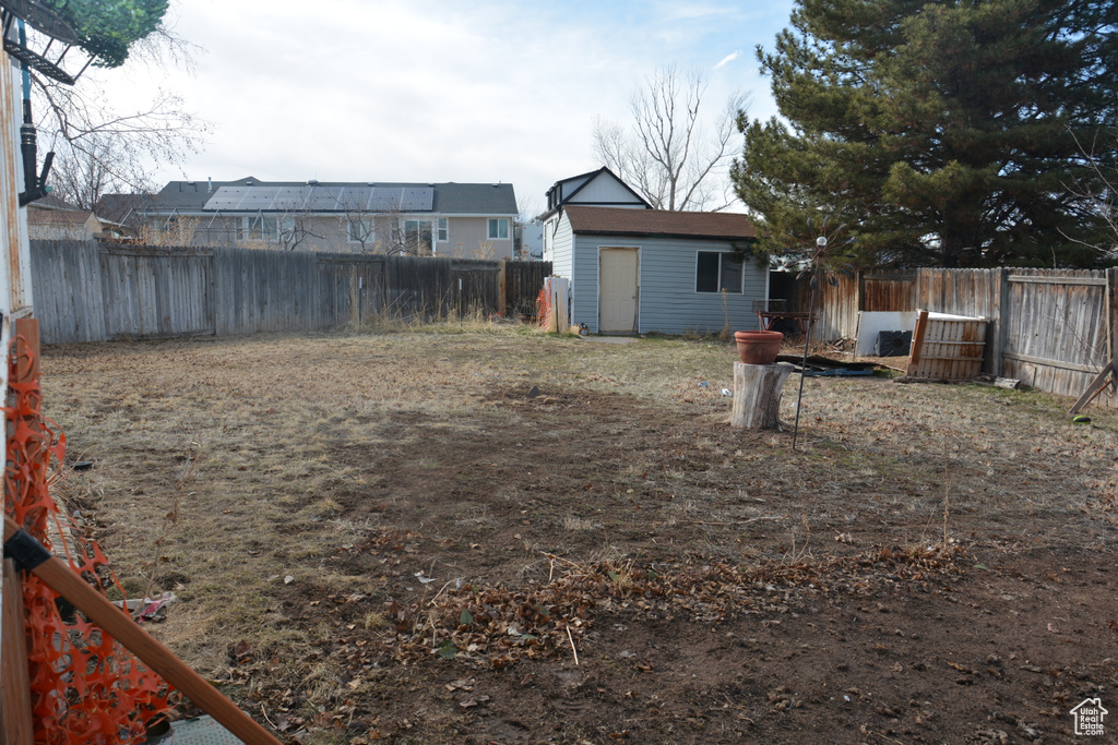 View of yard featuring an outbuilding, a shed, and a fenced backyard