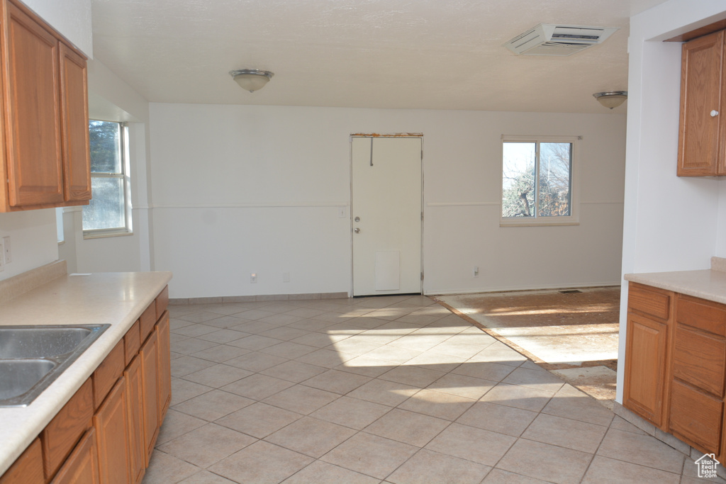 Kitchen with a wealth of natural light, light countertops, a sink, and light tile patterned floors