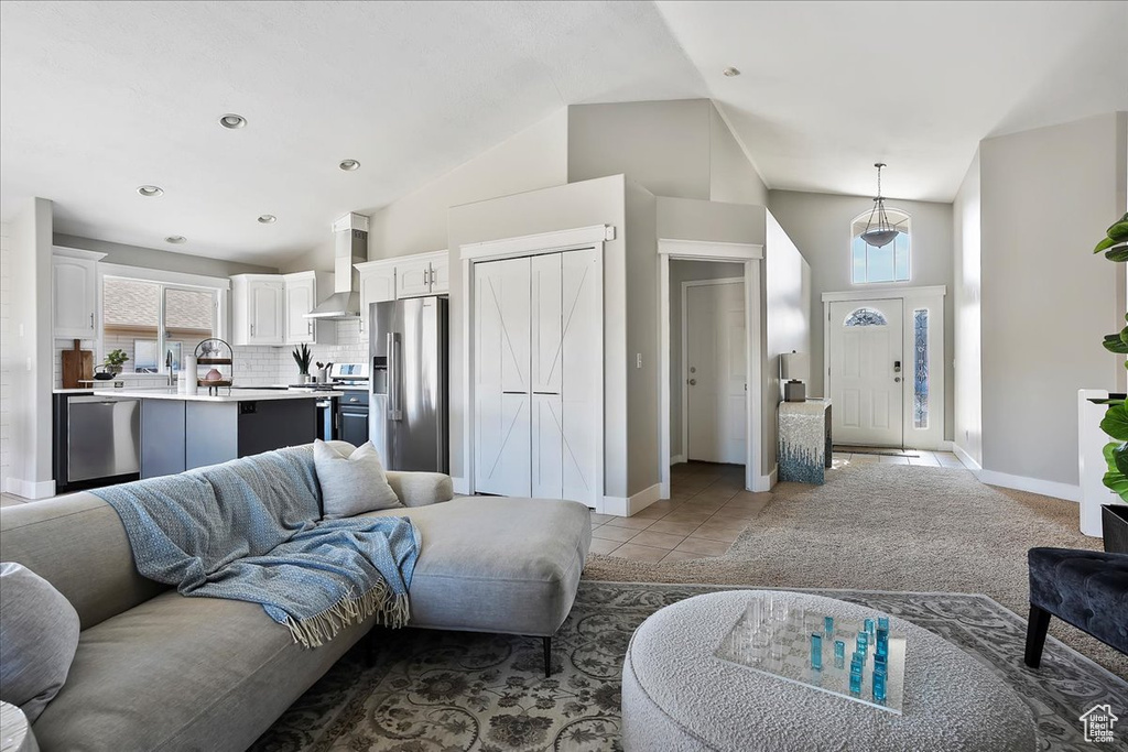 Living room featuring high vaulted ceiling, recessed lighting, baseboards, and light tile patterned floors